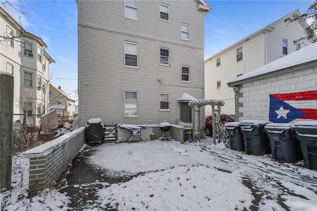 view of snow covered back of property