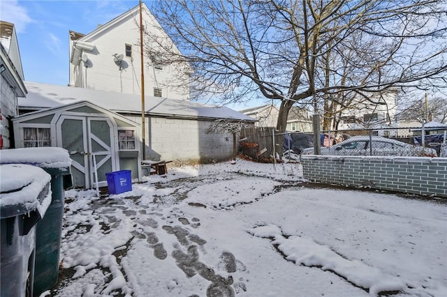 yard covered in snow with a shed