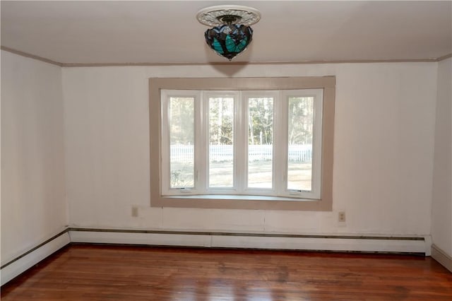 spare room with crown molding, dark wood-type flooring, and a baseboard radiator