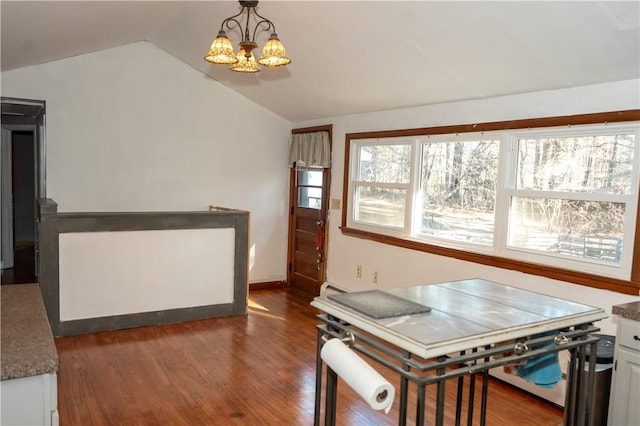 kitchen with lofted ceiling, an inviting chandelier, hanging light fixtures, dark hardwood / wood-style floors, and white cabinetry