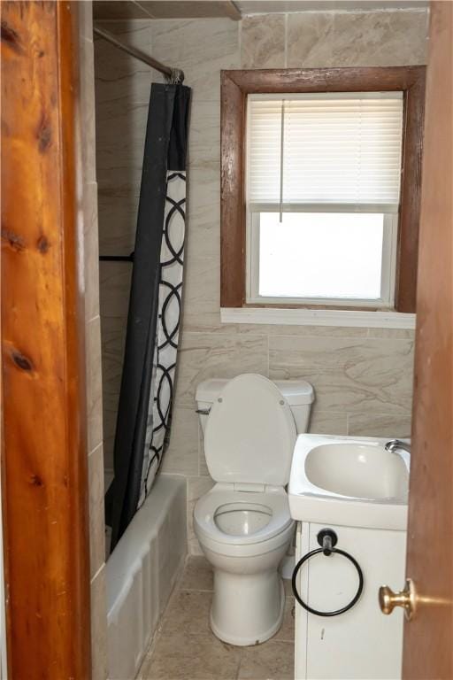 full bathroom featuring shower / tub combo with curtain, sink, tile walls, tile patterned flooring, and toilet