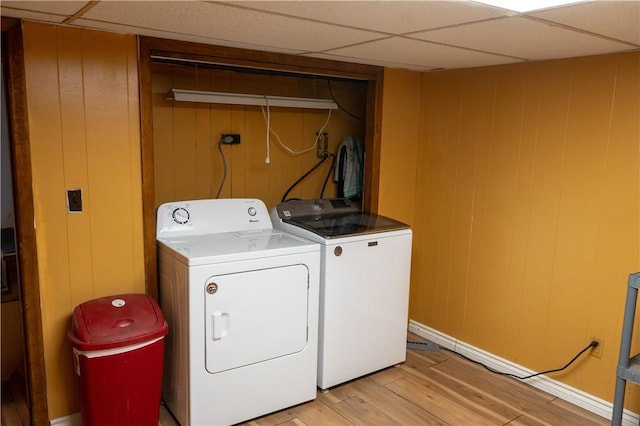 washroom featuring wood walls, light hardwood / wood-style flooring, and washer and dryer