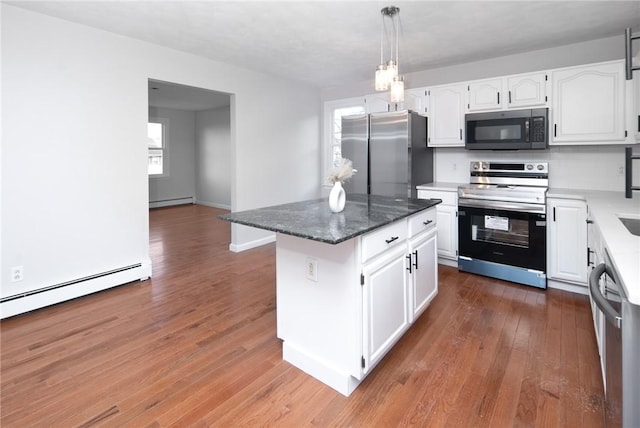 kitchen with appliances with stainless steel finishes, a center island, white cabinetry, and a baseboard heating unit