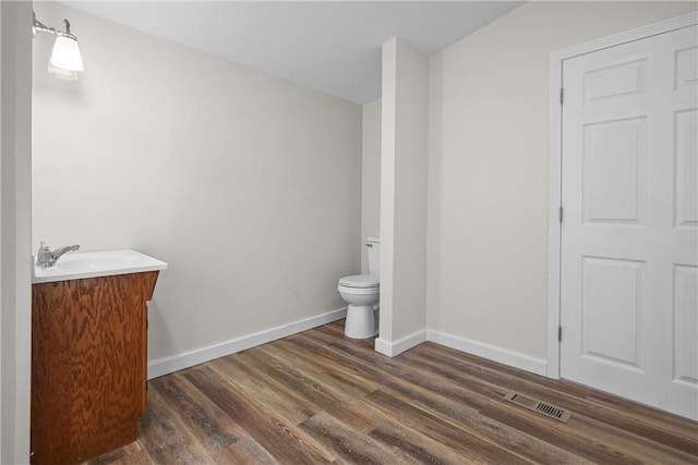 bathroom with vanity, hardwood / wood-style flooring, and toilet