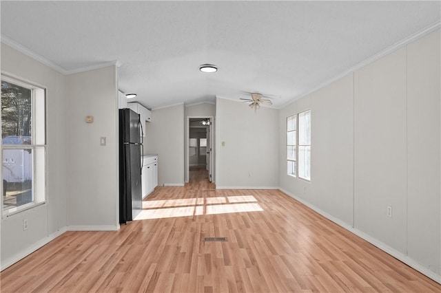 unfurnished living room featuring crown molding, ceiling fan, vaulted ceiling, and light wood-type flooring