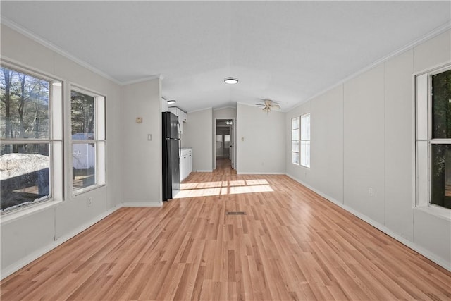 unfurnished living room featuring ceiling fan, light hardwood / wood-style floors, crown molding, and vaulted ceiling