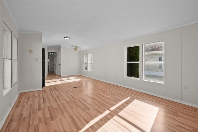 spare room featuring a healthy amount of sunlight, light hardwood / wood-style flooring, ceiling fan, and ornamental molding