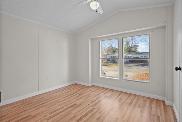 spare room featuring ceiling fan, vaulted ceiling, a textured ceiling, and light hardwood / wood-style flooring