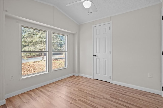 unfurnished room with a textured ceiling, ceiling fan, light hardwood / wood-style floors, and vaulted ceiling