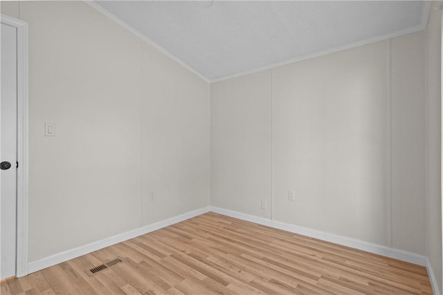 spare room with light hardwood / wood-style floors and ornamental molding