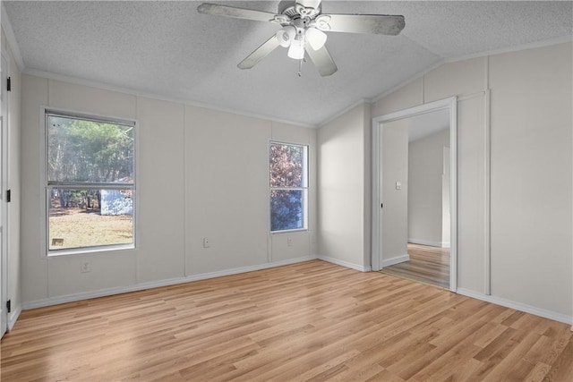 spare room featuring ceiling fan, vaulted ceiling, a textured ceiling, and light hardwood / wood-style flooring