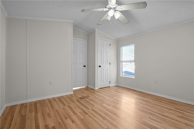 spare room featuring crown molding, ceiling fan, lofted ceiling, and light wood-type flooring