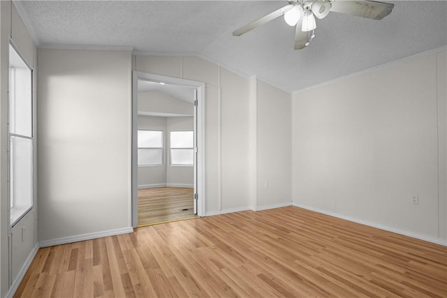 interior space featuring ceiling fan, light wood-type flooring, a textured ceiling, and lofted ceiling