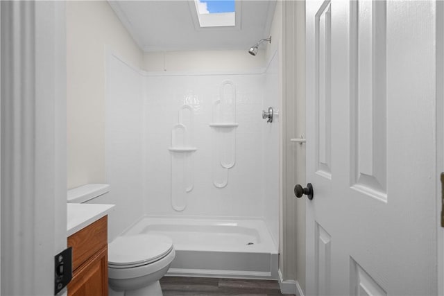 bathroom featuring a skylight, vanity, a shower, hardwood / wood-style floors, and toilet