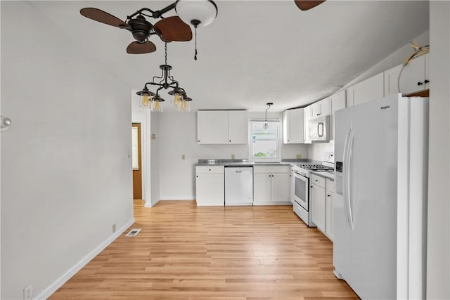 kitchen featuring pendant lighting, ceiling fan with notable chandelier, white cabinetry, and white appliances