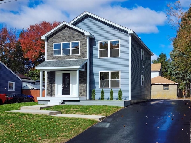 view of front of property with a front lawn, an outdoor structure, and a garage