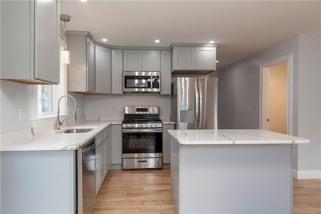 kitchen featuring sink, gray cabinetry, stainless steel appliances, and a kitchen island