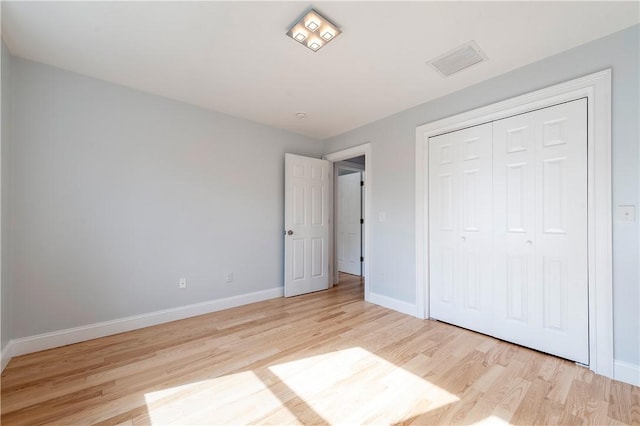 unfurnished bedroom featuring a closet and light hardwood / wood-style flooring