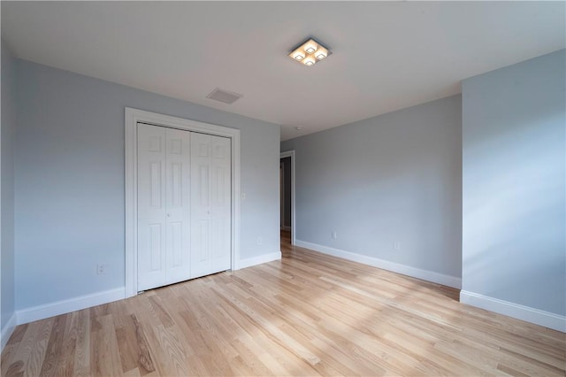 unfurnished bedroom featuring a closet and light wood-type flooring