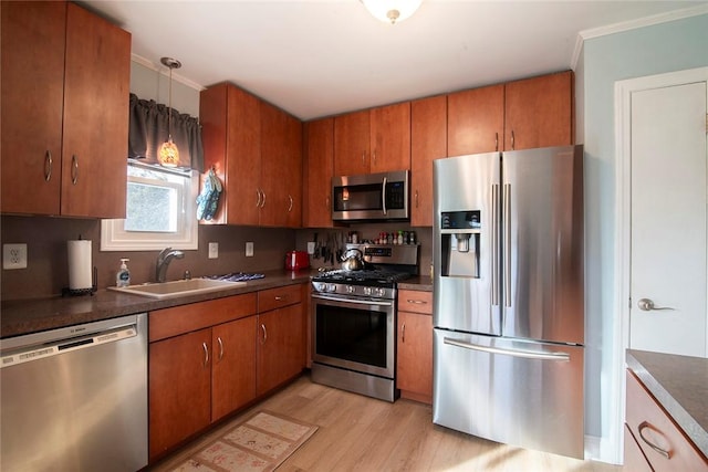 kitchen with sink, hanging light fixtures, light hardwood / wood-style flooring, decorative backsplash, and stainless steel appliances