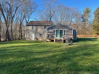 rear view of property featuring a deck and a yard