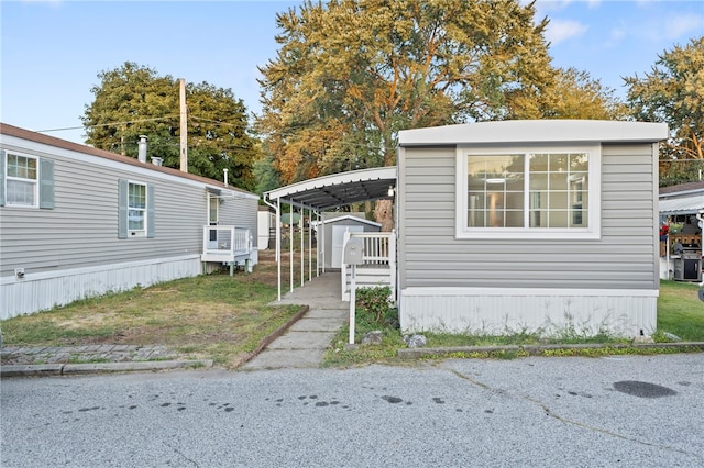 view of front facade featuring a carport and a storage unit