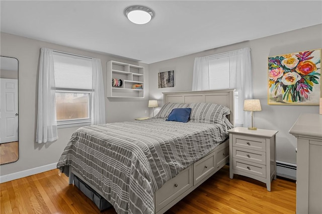 bedroom with light wood-type flooring and baseboard heating