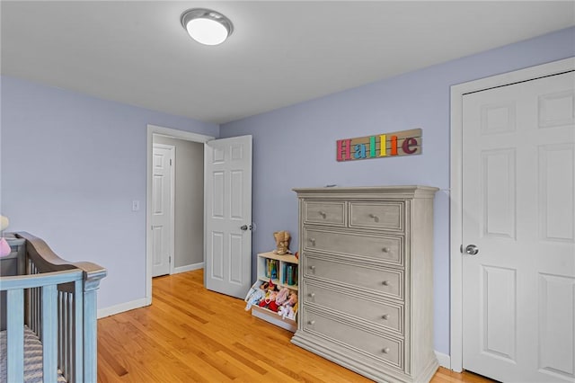 bedroom featuring a crib and hardwood / wood-style flooring