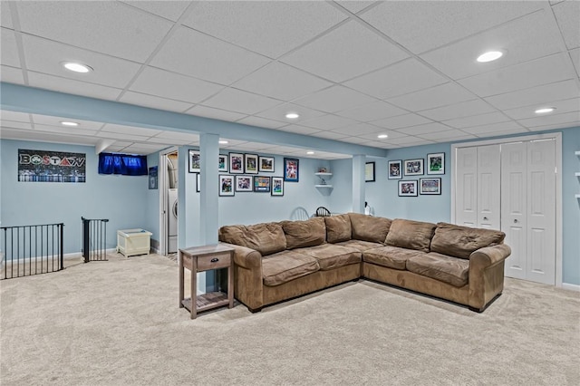 carpeted living room with a drop ceiling