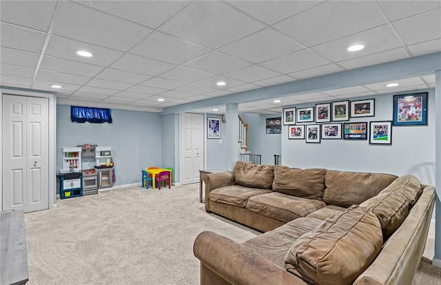 carpeted living room featuring a paneled ceiling