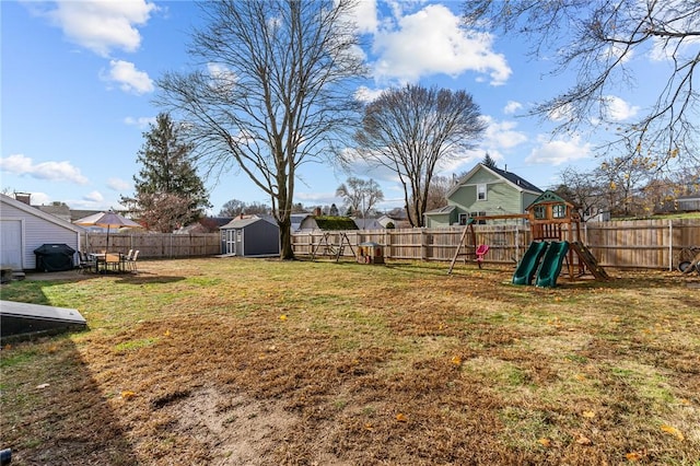 view of yard with a playground and a storage shed