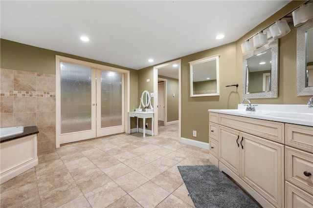 bathroom with tile patterned floors, a bathtub, french doors, and vanity