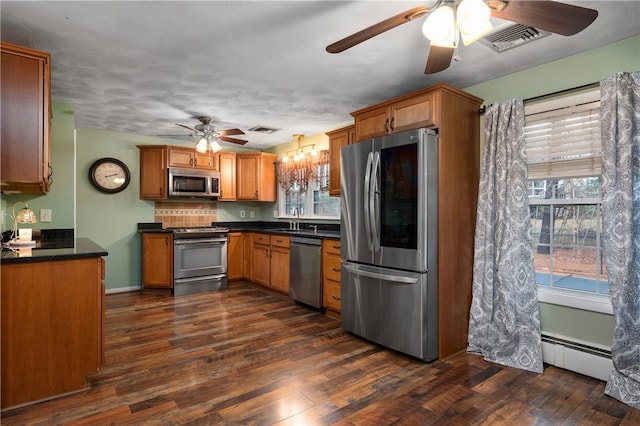 kitchen with a baseboard radiator, dark hardwood / wood-style flooring, stainless steel appliances, sink, and ceiling fan