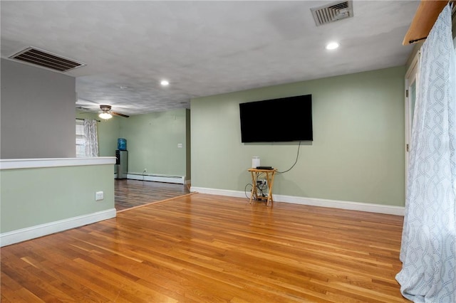 unfurnished living room featuring light wood-type flooring, ceiling fan, and baseboard heating