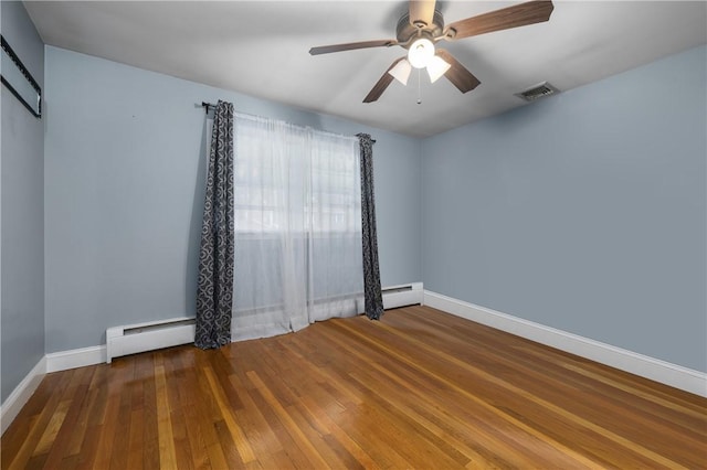 spare room with a baseboard heating unit, ceiling fan, and dark hardwood / wood-style flooring