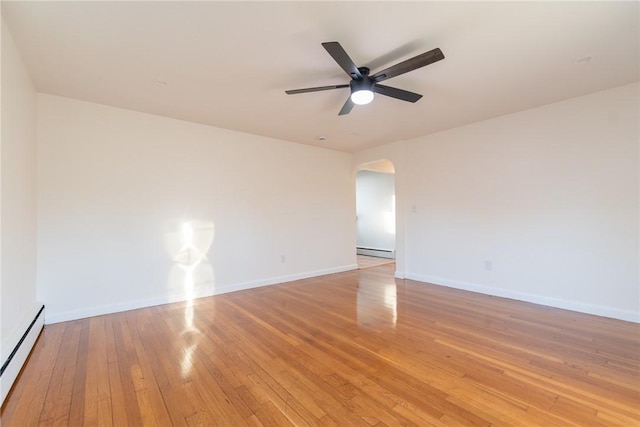 spare room with hardwood / wood-style flooring, ceiling fan, and a baseboard heating unit