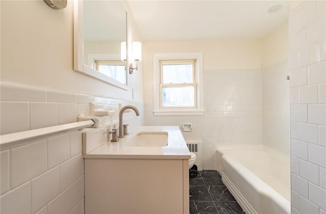 bathroom featuring radiator, vanity, tile walls, and toilet