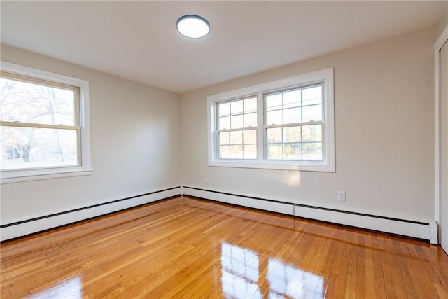 spare room featuring light wood-type flooring and baseboard heating