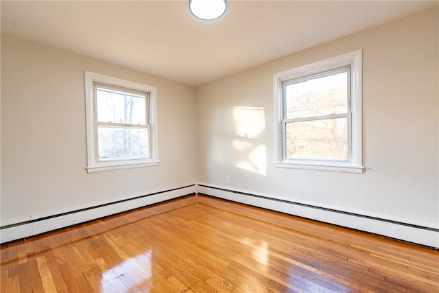 unfurnished room featuring light hardwood / wood-style flooring and a baseboard heating unit