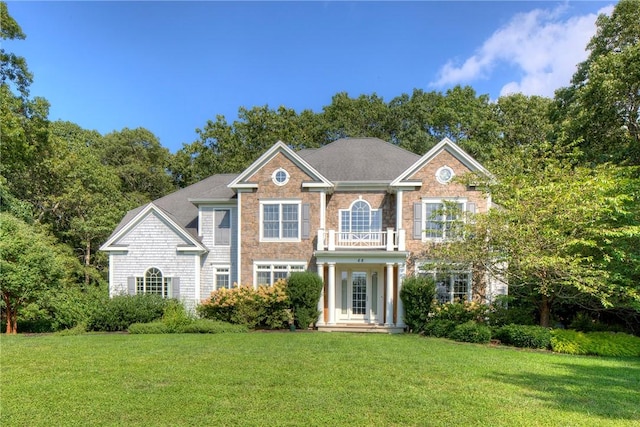 view of front of property with a balcony and a front lawn