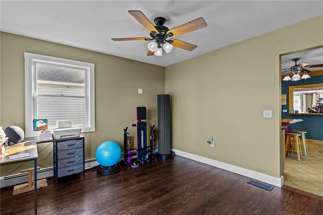 office space with dark hardwood / wood-style floors, baseboard heating, and ceiling fan