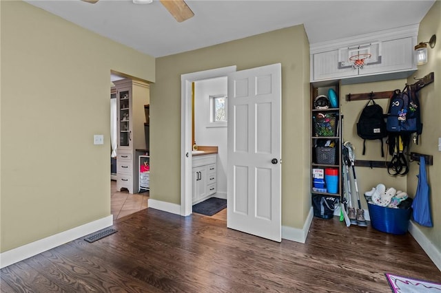 bedroom featuring dark hardwood / wood-style flooring, connected bathroom, and ceiling fan