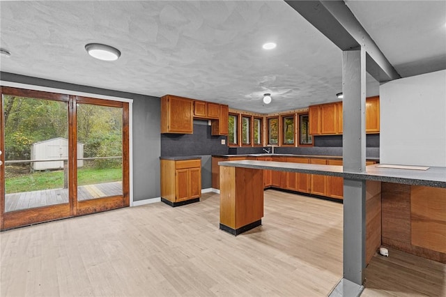 kitchen with kitchen peninsula, a breakfast bar, and light hardwood / wood-style floors