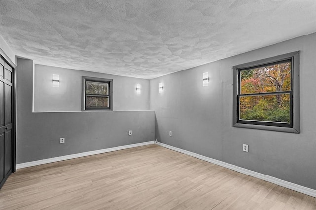 empty room featuring a textured ceiling and light wood-type flooring