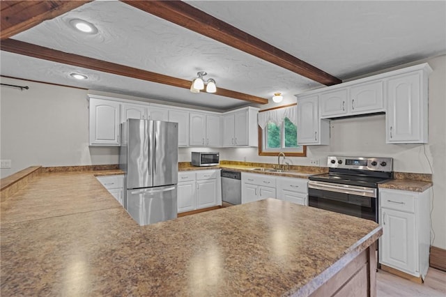 kitchen featuring kitchen peninsula, appliances with stainless steel finishes, light wood-type flooring, sink, and white cabinets