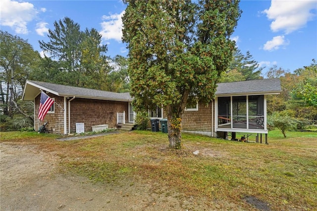 view of front of property featuring a front lawn and a sunroom