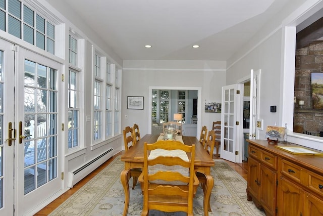 dining space featuring french doors, a baseboard radiator, and a healthy amount of sunlight