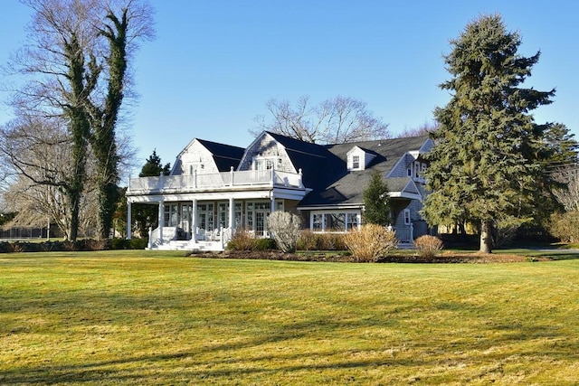 cape cod home with a balcony and a front yard