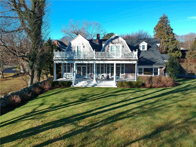 rear view of house featuring a yard, a balcony, and a patio area