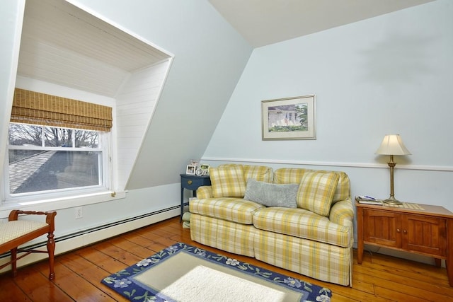 living area with hardwood / wood-style floors, vaulted ceiling, and a baseboard heating unit